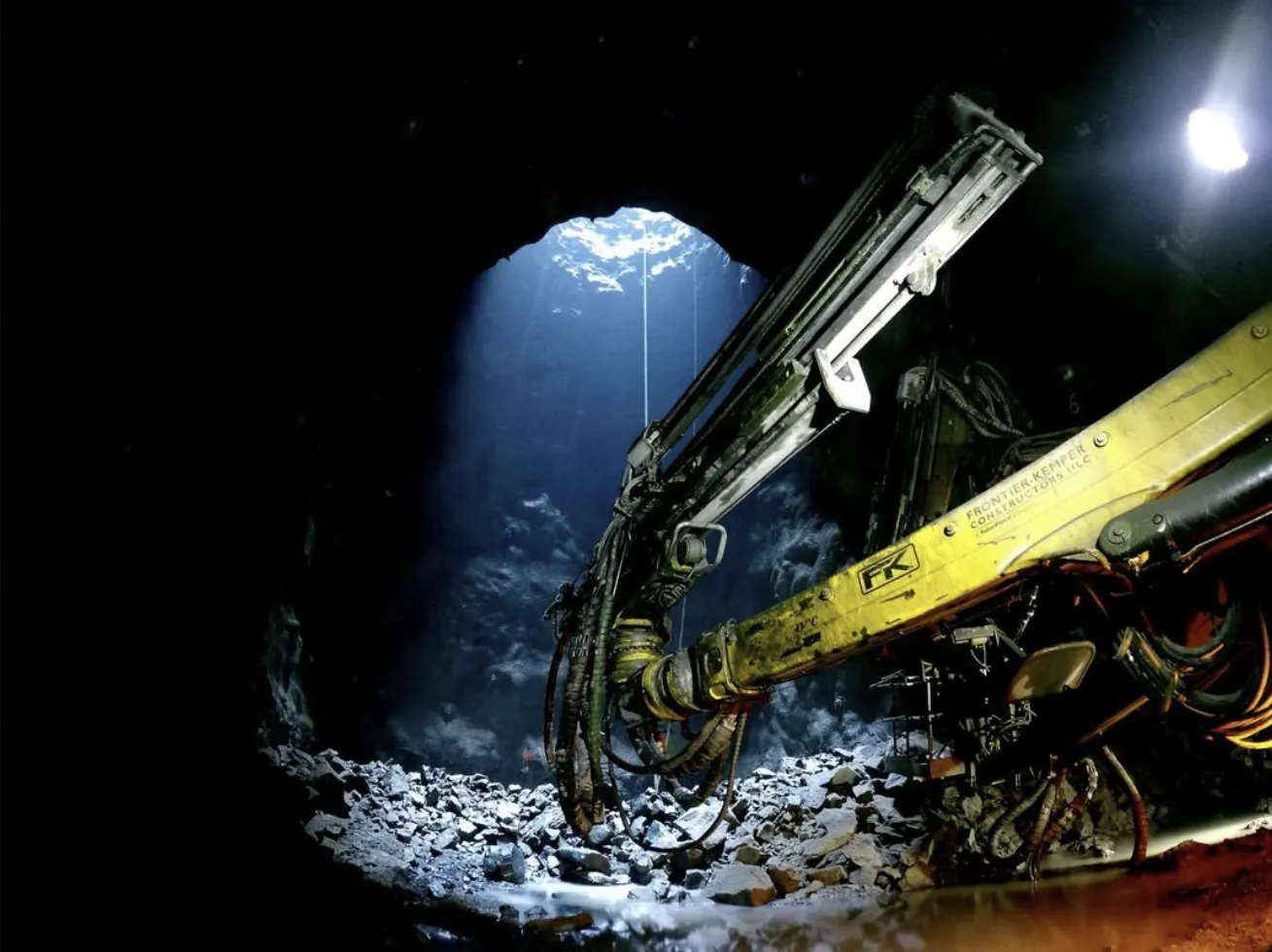 A shaft-sinking drill under light falling down the shaft.